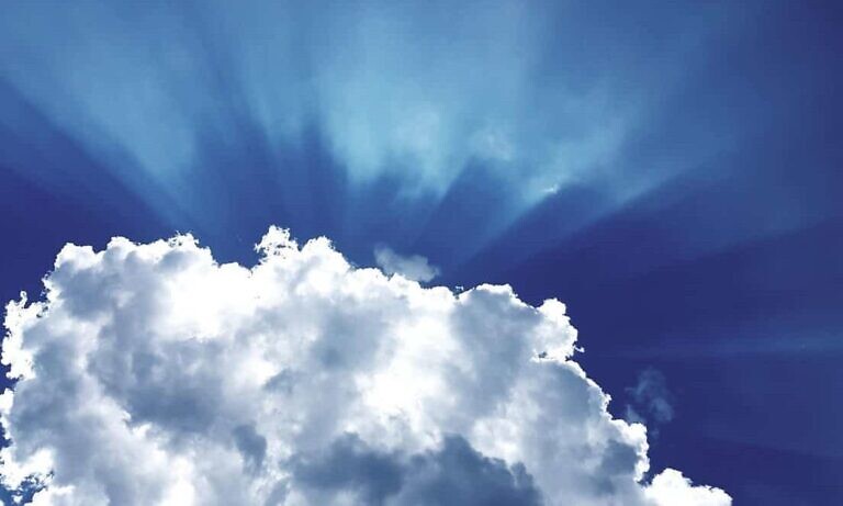 sun rays through white cumulus clouds
