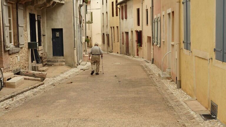 man in gray jacket walking on street during daytime