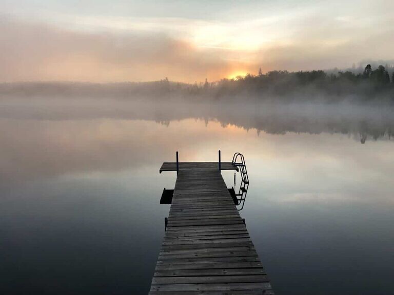 gray wooden pallet sea dock with fog