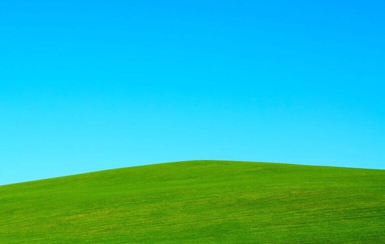 green hill under blue sky