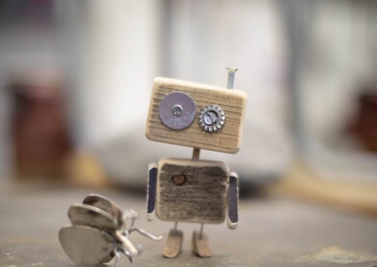 brown wooden robot with white and black cat